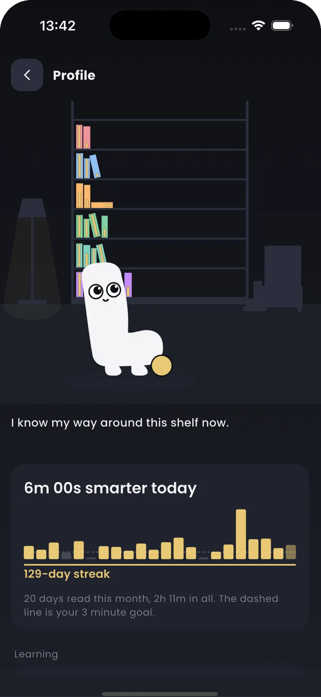 The profile screen: L. standing in front of a bookshelf filling up with coloured spines, above a card reading 6m 00s smarter today and a 129-day streak.